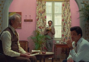 Arthur Howitzer et Roebuck Wright en conférence sur fond rose des murs dans The French Dispatch — Wes Anderson