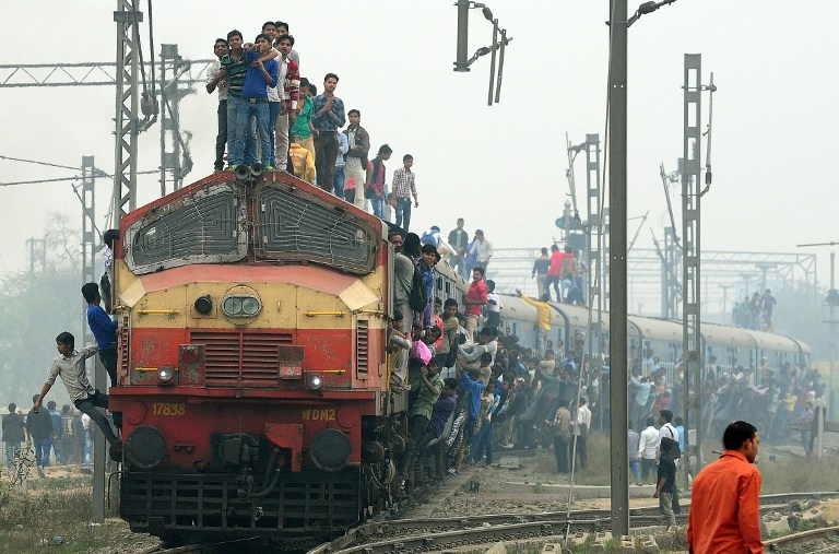 Train en Inde — passagers s'accrochant sur les côtés du train ou montés sur le toit.