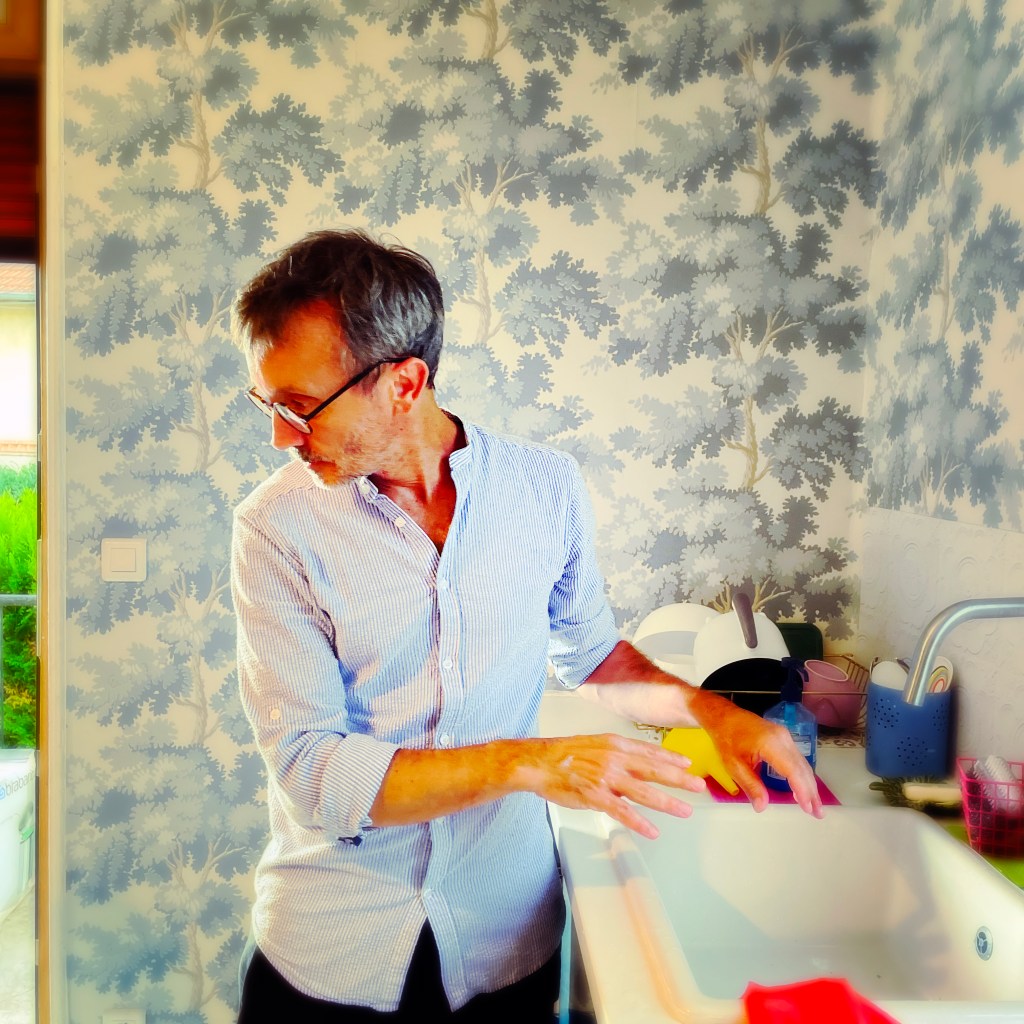 Cousin Louis faisant la vaisselle tout en surveillant son fils du coin de l'œil — ph © Clémence Zagorski